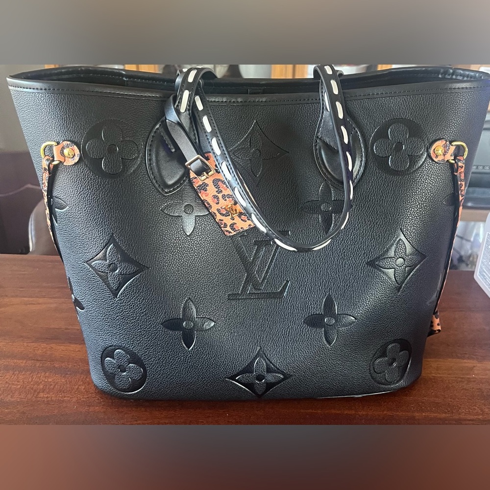 Black leather tote bag with cheetah print accents.